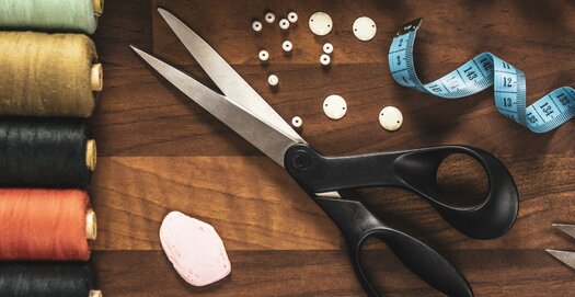 Schneider-Zubehör wie eine Schere, ein Maßband, Knöpfe, Nähgarn